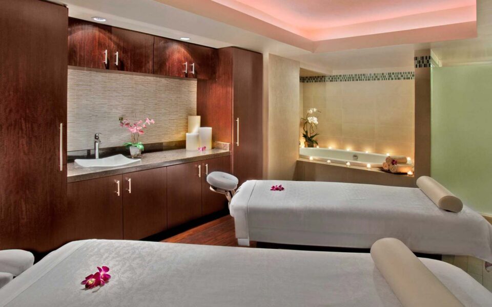 two intimate massage beds in a room with candles lit