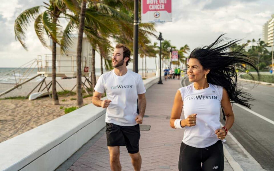 man and woman running down the boardwalk